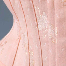 Close up of vintage salmon pink patterned floral coutil
