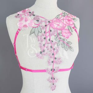 Bright pink floral lace body harness with pink adjustable elastic straps with silver metal rings and sliders
